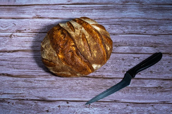 Tahta masada bir somun ekmek ve bir bıçak.