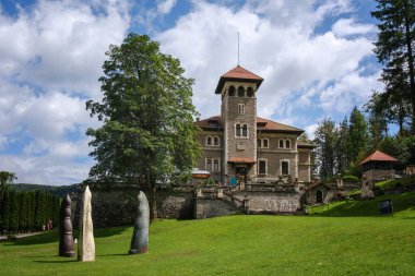 Busteni, Romanya - 24 Haziran 2024: Busteni 'deki Bahçe Heykelleri ve Mavi Gökyüzü Şatosu.