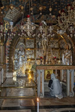Tapınan kişi çarmıha gerilmeden önce gümüş süslemelerle diz çöküyor, Kutsal Mezar Kilisesi, Kudüs.