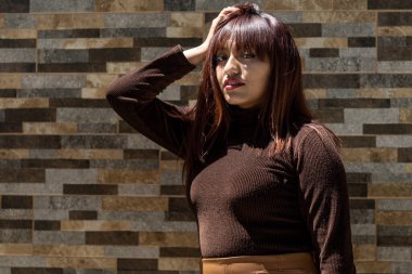 Güzel bir esmer kadın günlük kıyafetler giyiyor.