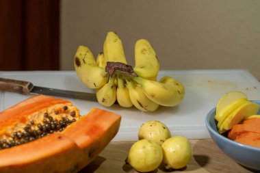 Ahşap arka planda kesim tahtasındaki meyve çeşitleri.