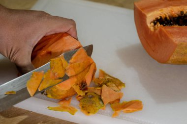 Kesme tahtasında taze papaya soymak. Sağlıklı beslenme kavramı.