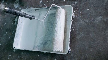 Beyaz boya uygulayan boya silindiri