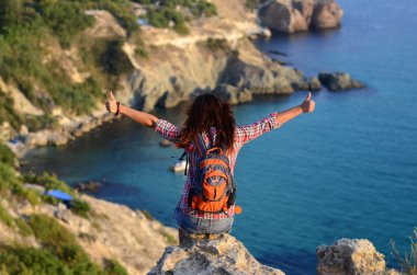 Arkadan görünüşü Cliff'in kenarında oturan genç kadın