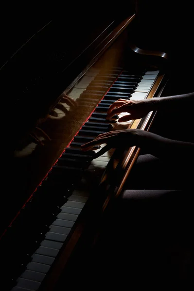 Las manos de la mujer en el teclado del piano en primer plano de la noche —  Fotos de Stock