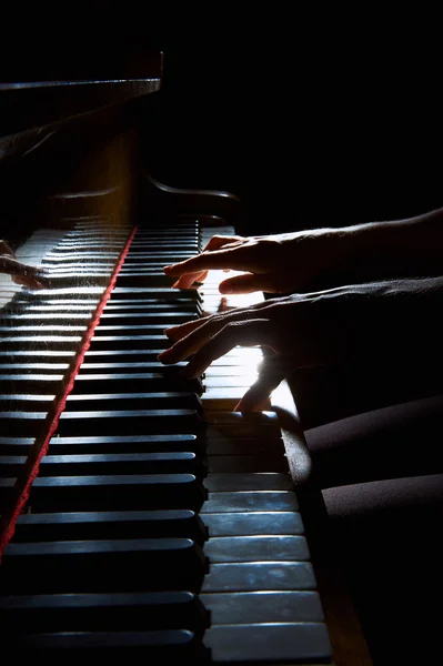 Les mains de la femme sur le clavier du piano dans le gros plan de nuit — Photo
