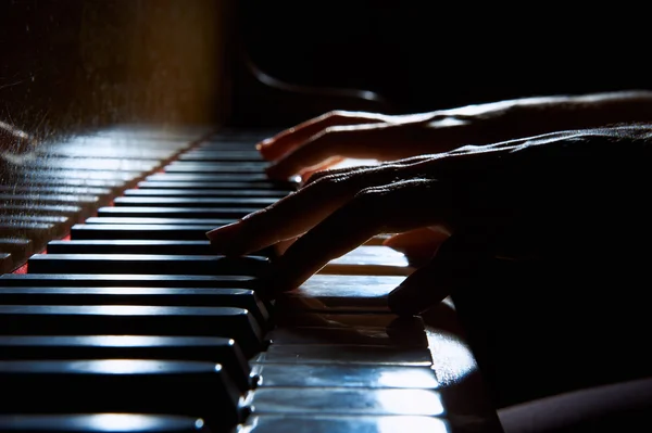 Les mains de la femme sur le clavier du piano dans le gros plan de nuit — Photo