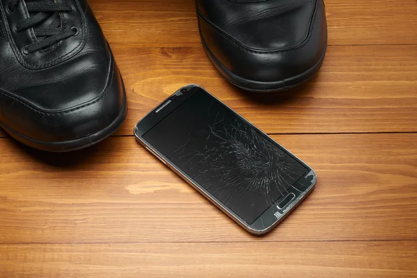 Smartphone quebrado caiu em sapatos — Fotografia de Stock