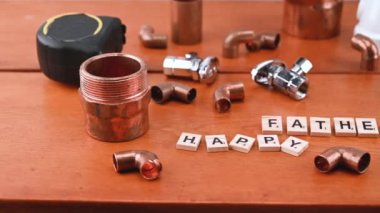 Babalar günü konsepti farklı bakır su boruları ve tesisatçı aletleriyle çevrili..