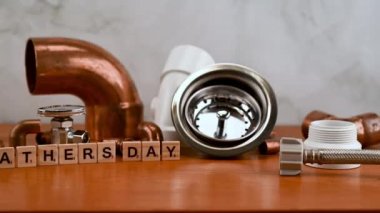 Babalar günü konsepti farklı bakır su boruları ve tesisatçı aletleriyle çevrili..