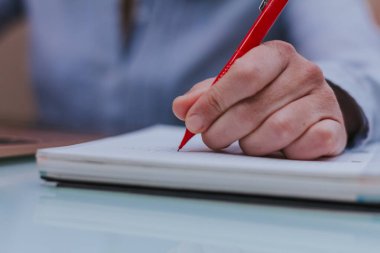 Not defterine kırmızı kalem yazan kadın elleri..