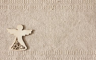 Doğal pamuk çizgili renksiz çuval bezi arka planda tahta bir melek figürü var.