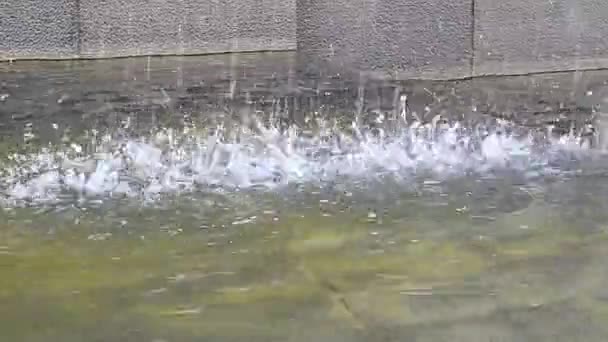 Gotas de água caem de cima para a superfície lisa da água. Jatos de derramamento de água formam salpicos quando soltos. — Vídeo de Stock