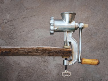 Old meat grinder on a wooden board clipart