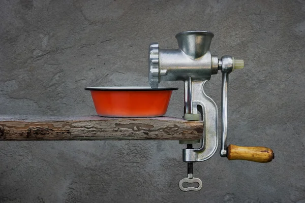 Старая мясорубка и красная эмалированная чаша — стоковое фото