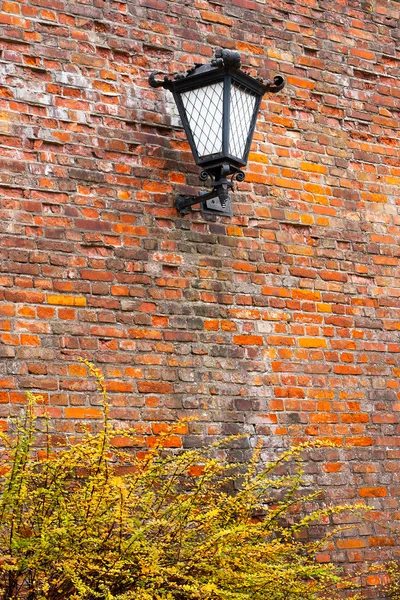 Alte Laterne auf einer Ziegelmauer — Stockfoto