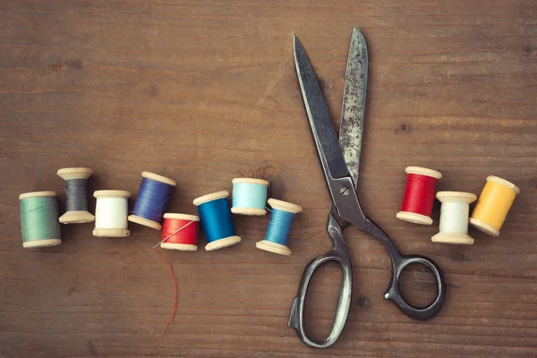 Scissors and wooden spools of thread — Stock Photo, Image