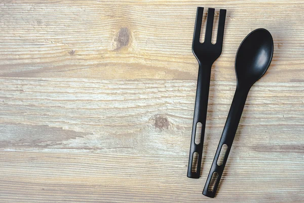 Cuillère et fourchette sur une planche en bois — Photo