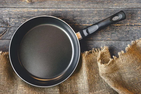 Een lege pan op een houten tafel — Stockfoto