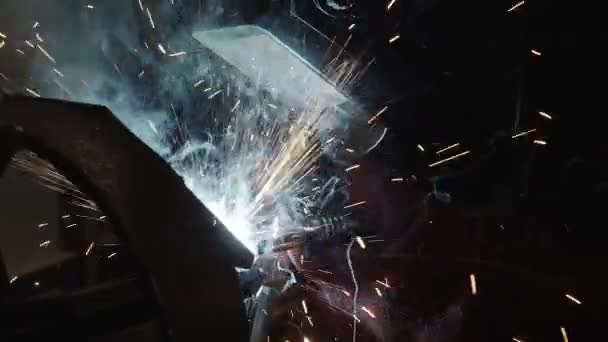 Крупный план сварщика в защитной маске работает с металлической сталью, замедленное движение — стоковое видео