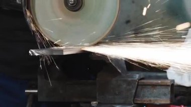 Bir fabrikada işçinin metali kestiği bir açı öğütücüsünün yakın çekimi, yavaş çekim