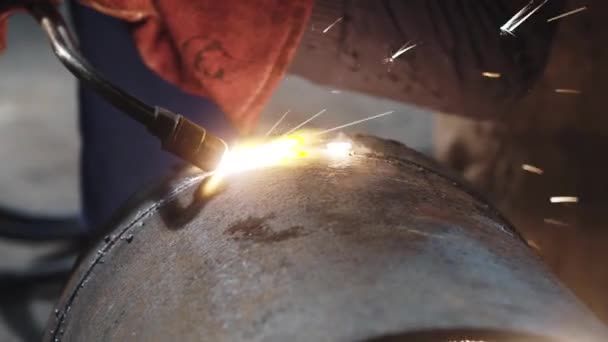 Un soldador corta un tubo de metal a chispas con una antorcha de corte a mano, primer plano — Vídeo de stock