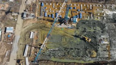 Güneşli bir günde inşaat alanındaki vinç, kazıcı ve çimento manzarası