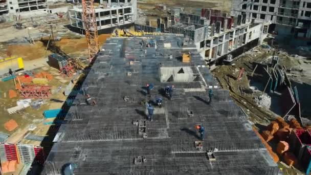Widok z lotu ptaka pracy zespołowej pracowników fizycznych na placu budowy w letni dzień — Wideo stockowe