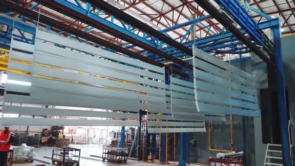 Silver metal panels move on an overhead conveyor. Powder coating line — Stock Video