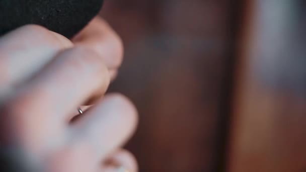 Close-up af mandlige hænder skaber en sort tegnebog ved hjælp af en nål og tråd – Stock-video