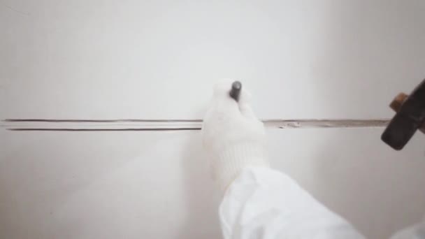 Primer plano de las manos de los trabajadores haciendo un agujero en la pared con un cincel y martillo — Vídeo de stock
