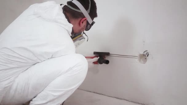 Чоловік в комбінезоні робить ремонт в квартирі, працює з болгаркою — стокове відео