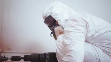 Beyaz bir adam soket için duvarda bir delik açıyor. Yüksek kalite 4k görüntü