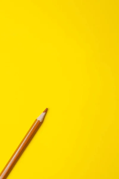 밝은 노란색 배경에 있는 대각선의 밝은 갈색의 날카로운 나무 연필은 분리되어 복사 공간을 가지고 — 스톡 사진