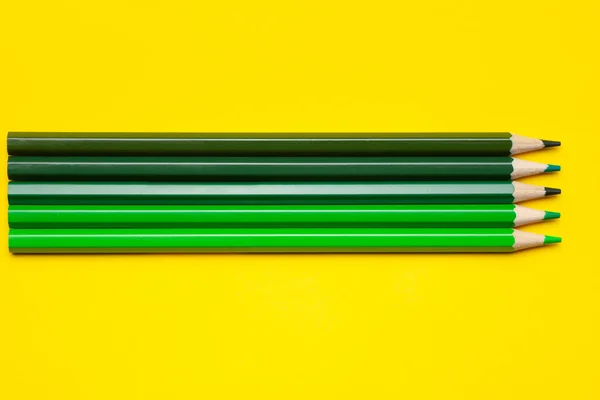 Horizontale grüne scharfe Holzstifte auf leuchtend gelbem Hintergrund, isoliert, Kopierraum, Attrappe — Stockfoto