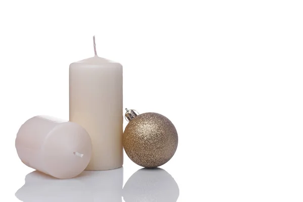Två beige vaniljljus och en jul Golden boll isolerad på en vit bakgrund — Stockfoto