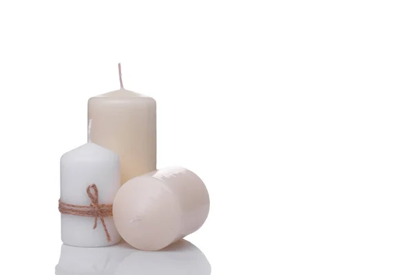 Ett vitt ljus i jute rep och två beige vaniljljus isolerad på en vit bakgrund — Stockfoto