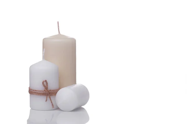 Одна біла свічка в джутовій мотузці, одна біла свічка лежить на його боці і бежева ванільна свічка ізольована на білому тлі — стокове фото
