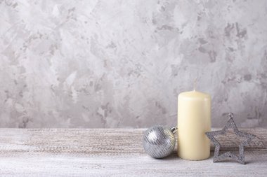Vanilya mumu, gümüş Noel balosu ve gümüş yıldız ahşap masada.