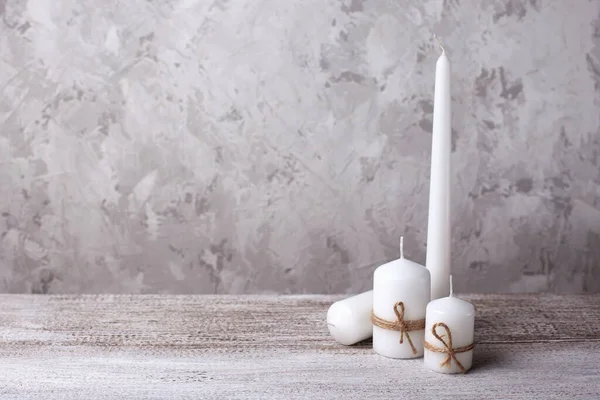 Mock upp av tre vita ljus i en jute rep och en lång vit ljus på en trä bakgrund — Stockfoto