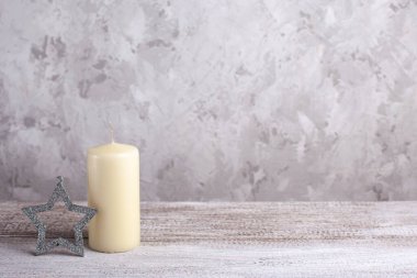Vanilya mumu modeli, ahşap bir masada gümüş yıldız, Noel kartı.