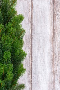 Ahşap bir arka planda yazı için yeri olan Noel ağacı dallarını taklit et