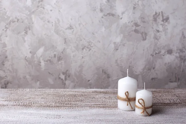 mock up of two white candles in a jute rope on a wooden table, Christmas card