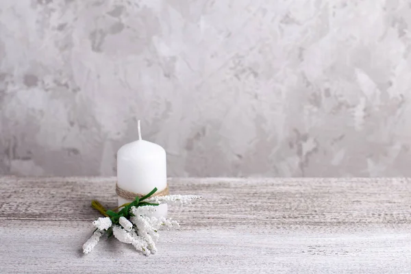 mock up of a white candle with a sprig of Muscari on a wooden table, card