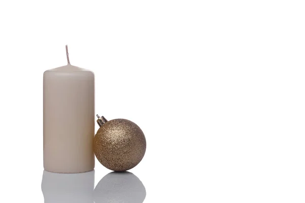 Beige vaniljljus och en jul Golden boll isolerad på en vit bakgrund — Stockfoto