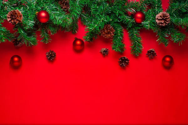 Postal con espacio de copia de una guirnalda de árbol de Navidad con conos, bolas rojas aisladas sobre un fondo escarlata — Foto de Stock