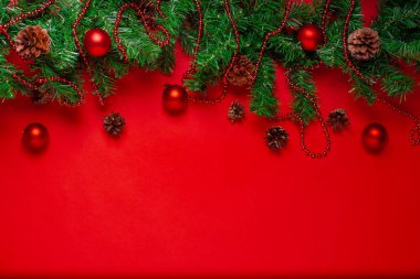 Noel ağacı çelengi, kırmızı toplar ve kırmızı arkaplanlı boncuklar için boşluk içeren kartpostal.