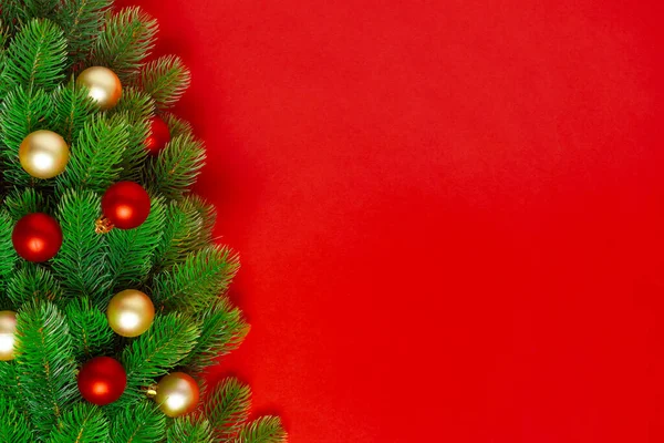 Postal de las ramas de un árbol de Navidad con globos rojos y dorados sobre un fondo rico, espacio para copiar — Foto de Stock