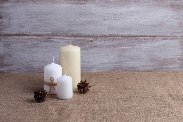 Mock upp av två vita ljus i jute rep och vaniljljus, kottar på en trä bakgrund och överlappning — Stockfoto