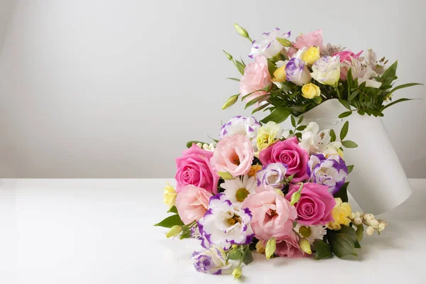 Mock up two bouquets of different sizes of roses, daisies, lisianthus, chrysanthemums, unopened buds in a white paper box on a white background, one bouquet lies on top of the other — Stock Photo, Image